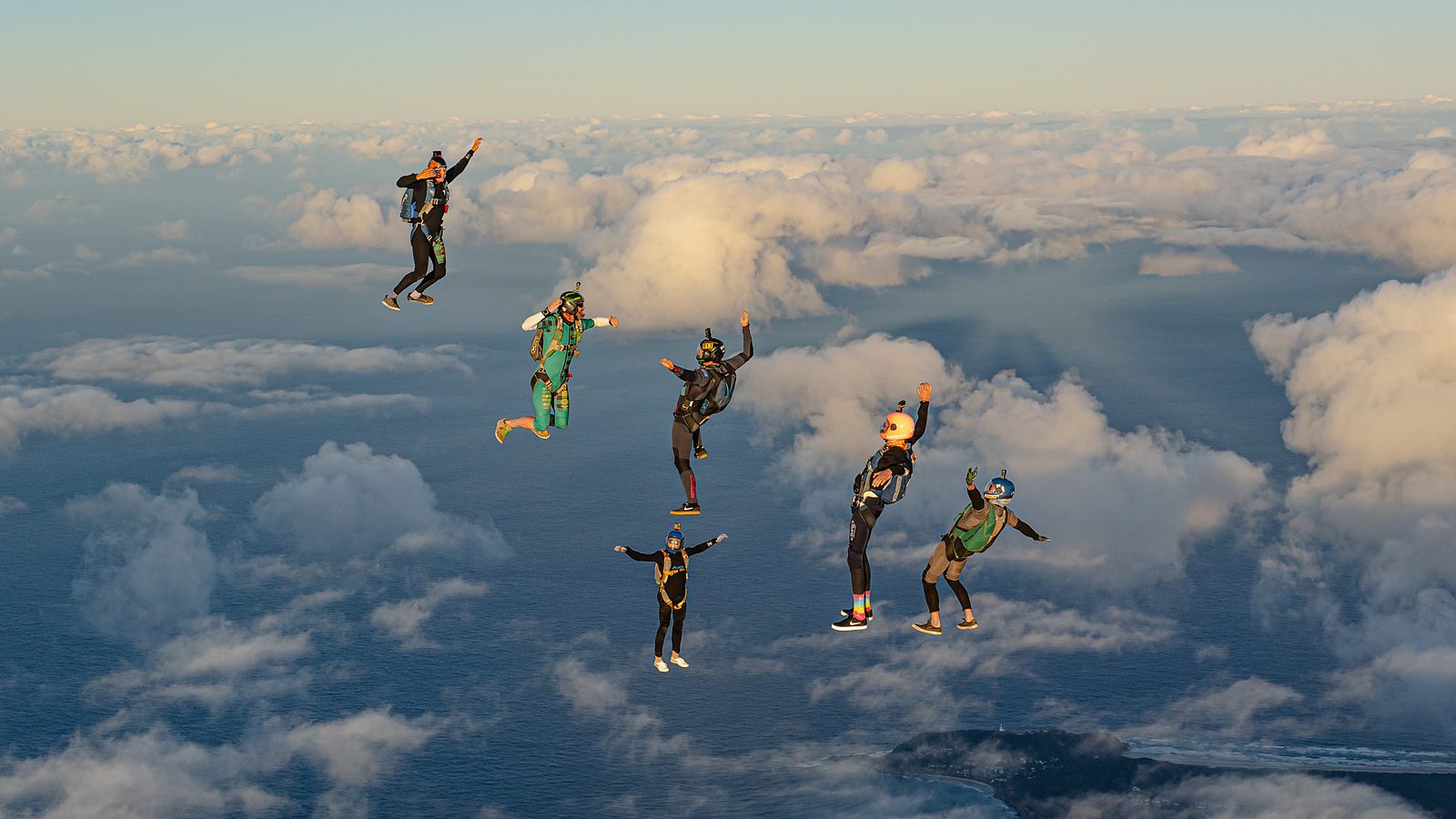 A skydiver dropping through a break in the cloud