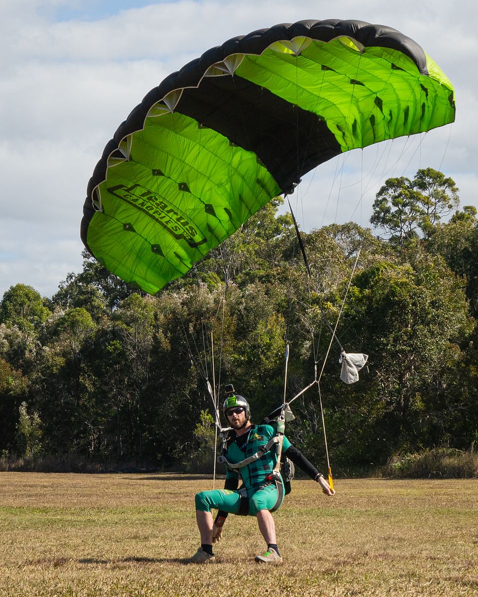 A jumper under canopy above green country