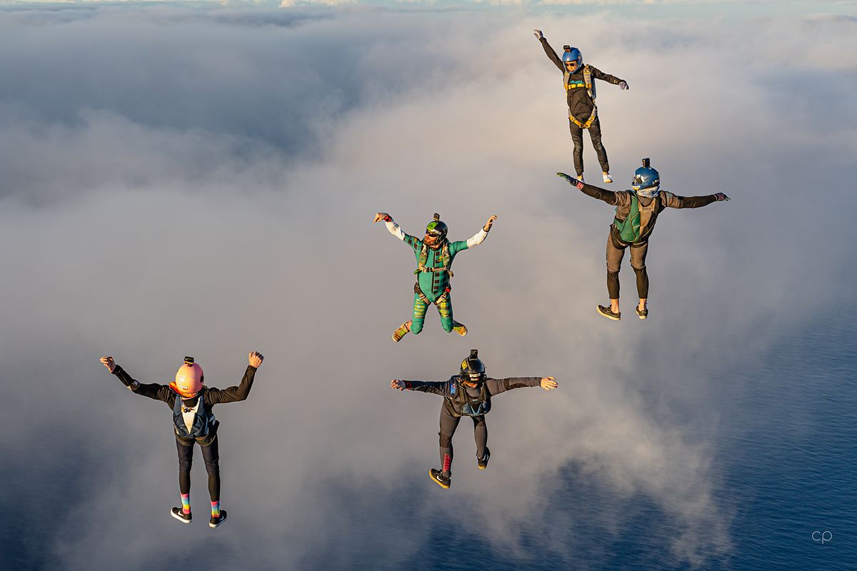 Flyers on the cloud tops with arms raised
