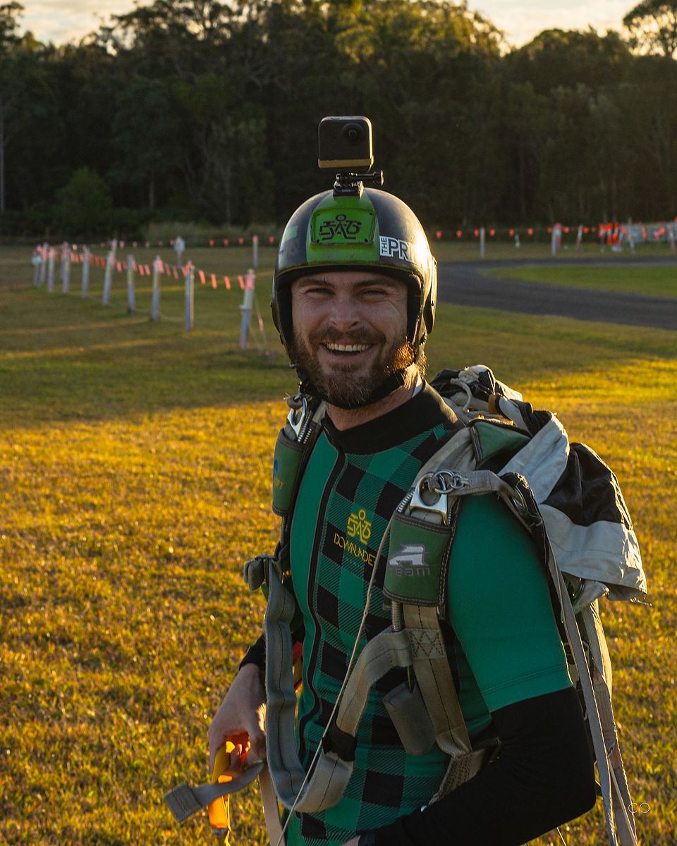 A skydiver on the landing area in a green suit