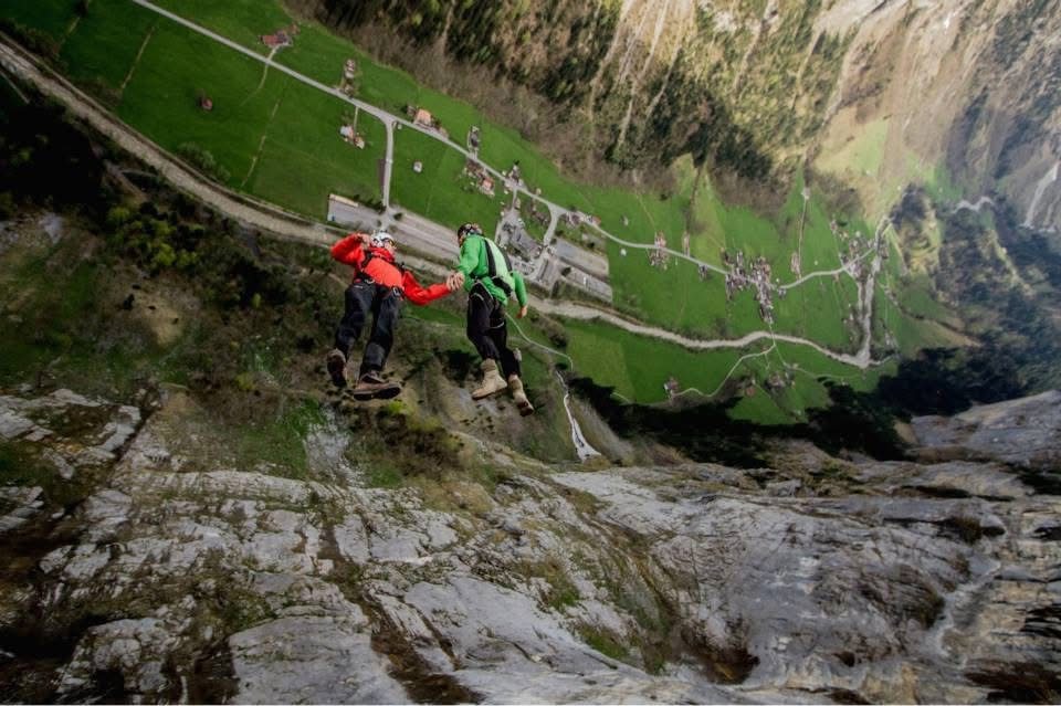 A BASE jumper tracking down a cliff face