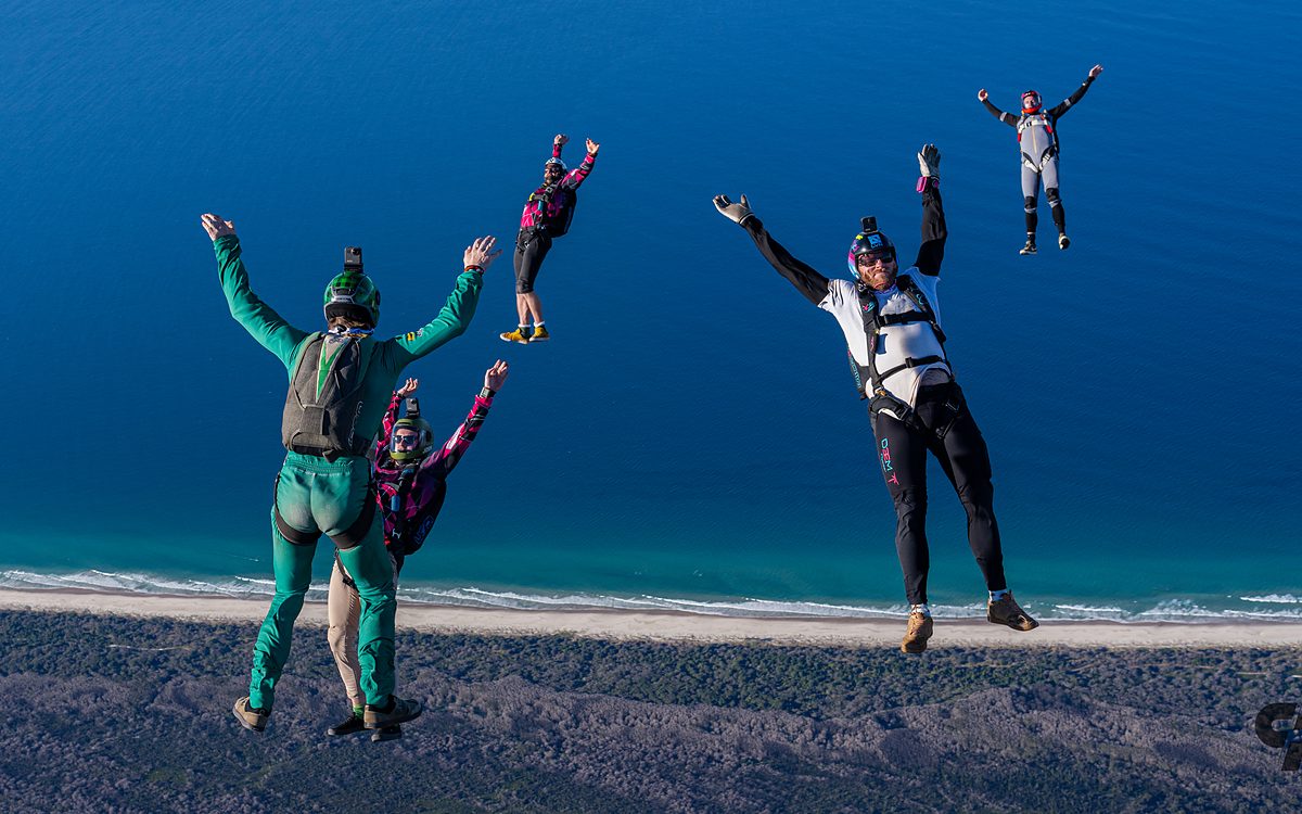 Two skydivers flying together against deep blue sky
