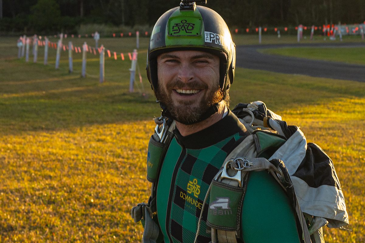 A skydiver in goggles and helmet in the aircraft before exit